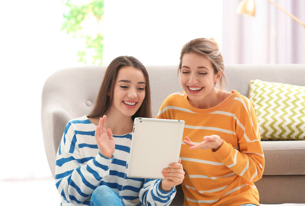 Women using tablet for video chat in living room - Fotó, kép