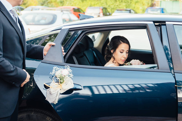 Papa öffnet der Braut die Autotür. - Foto, Bild