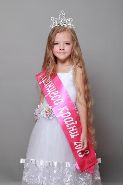 Beautiful girl in the crown was the most beautiful in a beauty contest in Ukraine Adorable little blond girl in a beautiful white dress and a crown won a tender little princesses - 写真・画像