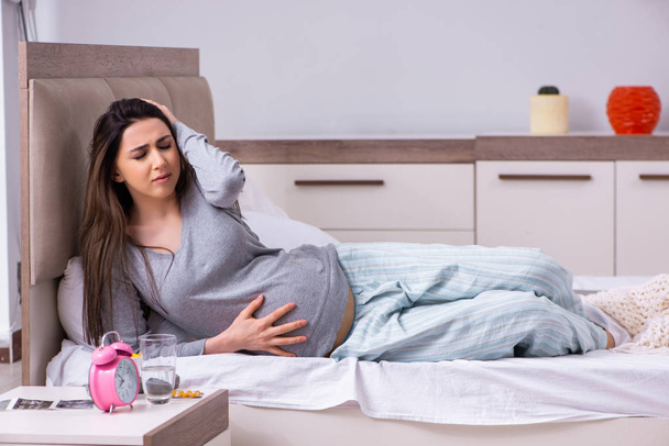 Mujer embarazada joven en el dormitorio  - Foto, Imagen