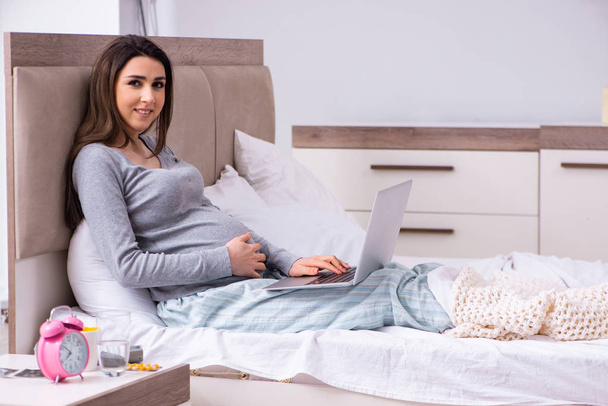 Young pregnant woman in the bedroom  - Foto, Bild