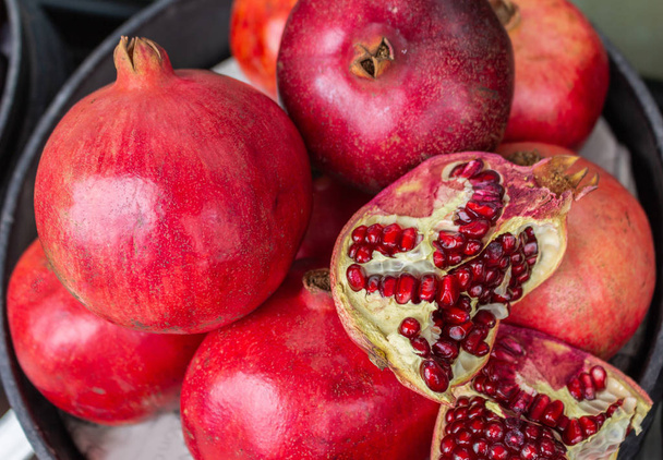 leckere rote Granatäpfel mit Schalen und freiliegenden Kernen - Foto, Bild