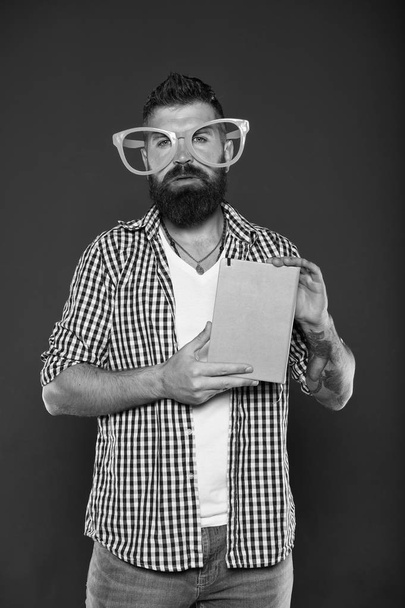 Hipster bearded man wear funny eyeglasses hold notepad or book. Bright up your day. Read this book. Comic and humor sense. Funny story. Study is fun. Funny book for relax. Book cover copy space - Фото, зображення
