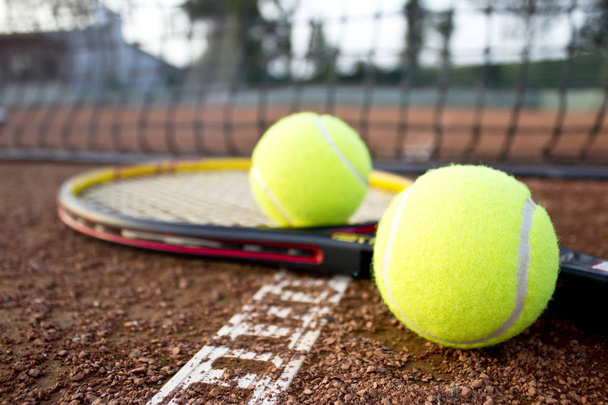 Tennis racket and balls on the clay tennis court. Close up. - Zdjęcie, obraz