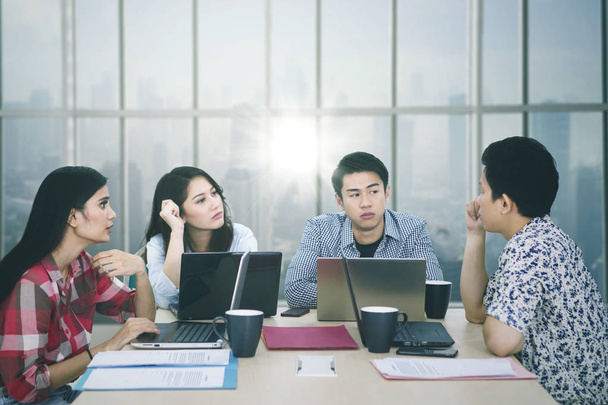 Young man discusses with his partners in the office - Foto, Imagem