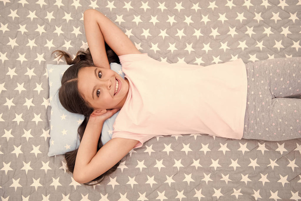 Girl child long hair lay awake top view. Quality of sleep depends on many factors. Girl lay on little pillow full of energy in morning bedclothes background. Choose proper pillow to sleep well - Valokuva, kuva