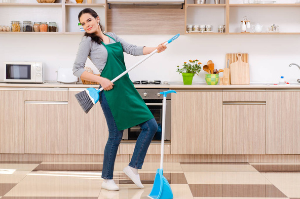 Jovem empreiteira fazendo tarefas domésticas
  - Foto, Imagem
