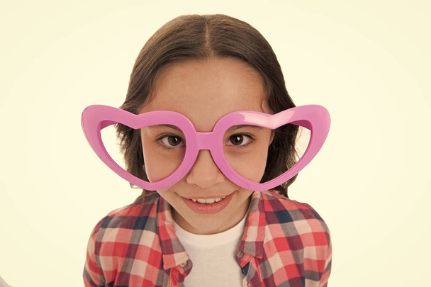 Love from first sight. Kid happy lovely feels sympathy. Kid girl heart shaped eyeglasses. Girl adorable smiling face in love. Child charming smile isolated white background. First love concept - Foto, afbeelding