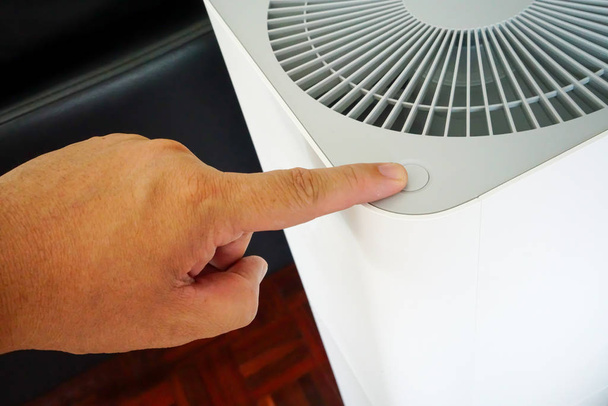 Κλείσιμο του χεριού που πιέζει το κουμπί του καθαριστή αέρα που τοποθετείται στο WDE - Φωτογραφία, εικόνα