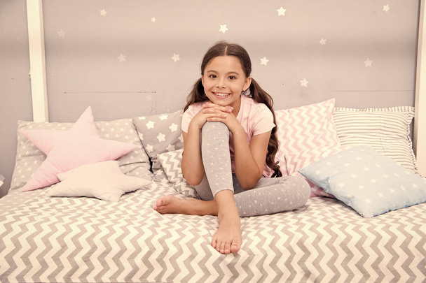 Wish her sweet dreams. Girl child sit on bed her bedroom. Kid prepare go to bed. Pleasant time relax cozy bedroom. Girl kid long hair cute pajamas relaxing before sleep. Time to sleep or nap - Photo, image