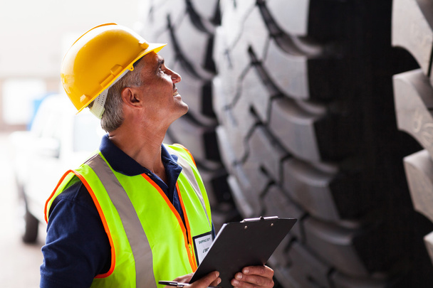 warehouse worker inspecting tires - Foto, immagini