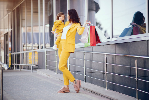 Mother and daughter with shopping bag in a city - Фото, зображення