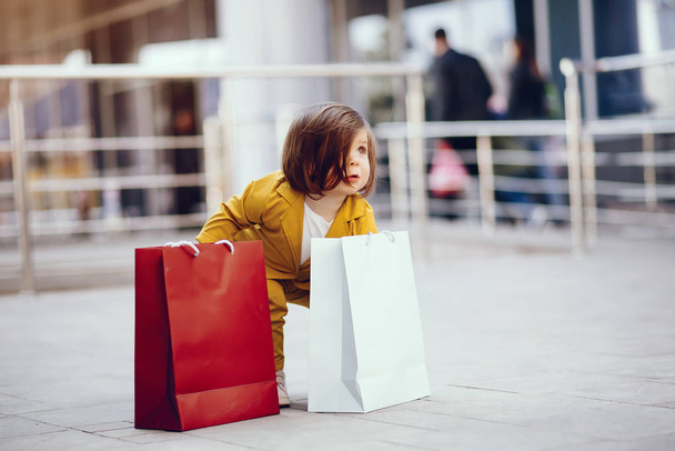 Linda niña con bolsa de compras en una ciudad
 - Foto, imagen