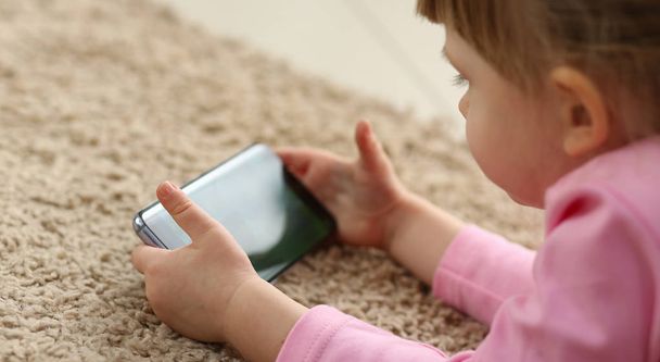 Маленькая хакерская девочка поколения z, использующая мобильный телефон для развлечения
 - Фото, изображение