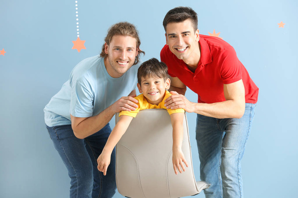 Счастливая гей-пара с усыновленным ребенком на цветном фоне
 - Фото, изображение