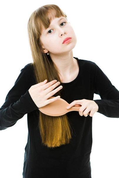 Naturally blonde girl in black dress brushing long straight hair - Zdjęcie, obraz