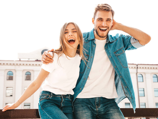 Portrait of smiling beautiful girl and her handsome boyfriend. Woman in casual summer jeans clothes. Happy cheerful family. Female having fun on the street background - Foto, Imagem