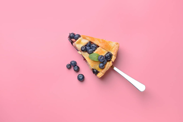 Piece of tasty blueberry pie on color background - Zdjęcie, obraz