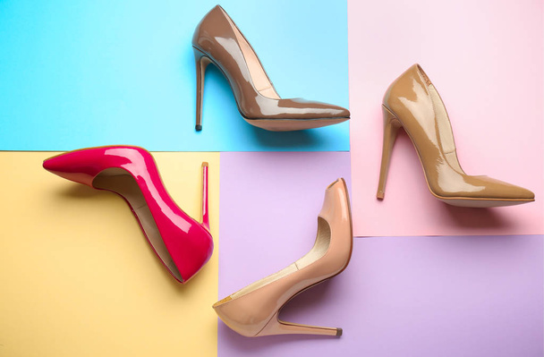 Different stylish high heeled shoes on color background - Photo, Image