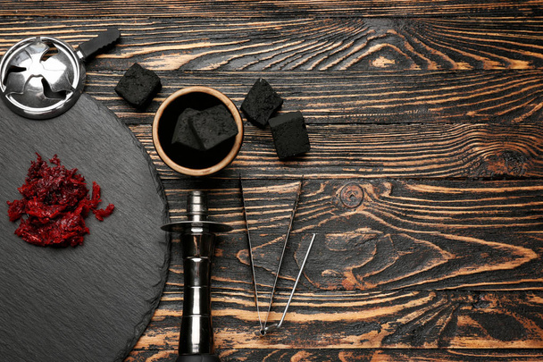 Parts of hookah and coal on wooden background - Foto, imagen