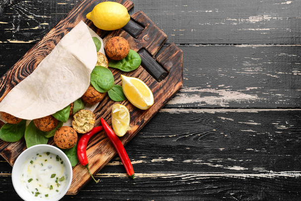 Tavola con gustose palline di falafel e salsa sul tavolo di legno
 - Foto, immagini