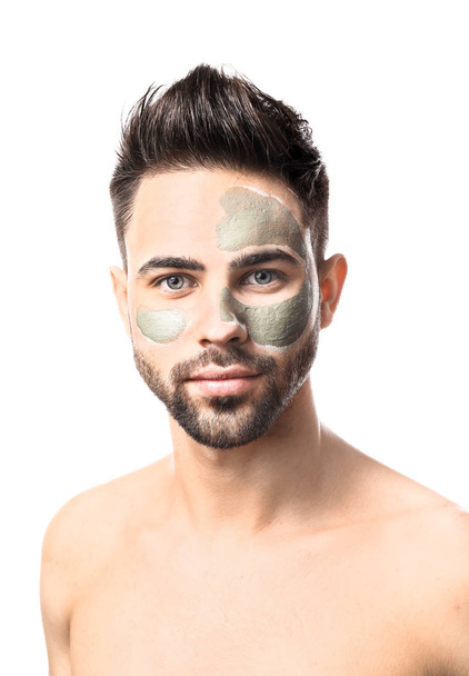 Handsome man with clay mask on his face against white background - Photo, Image