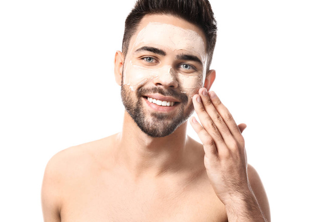Handsome man with clay mask on his face against white background - Foto, Bild