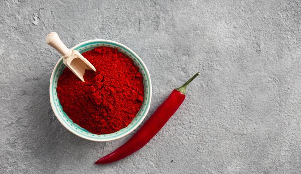 Chili pepper powder on concrete background with free space for text top view - Фото, изображение