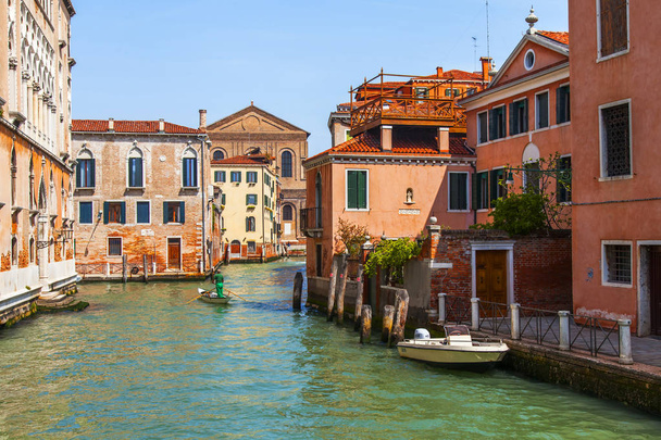 Venice, Italy, on April 25, 2019. Typical Venetian canal street and old buildings ashore - Foto, Imagen