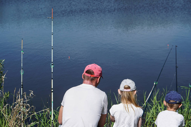 湖で釣りをする父と子供たち - 写真・画像