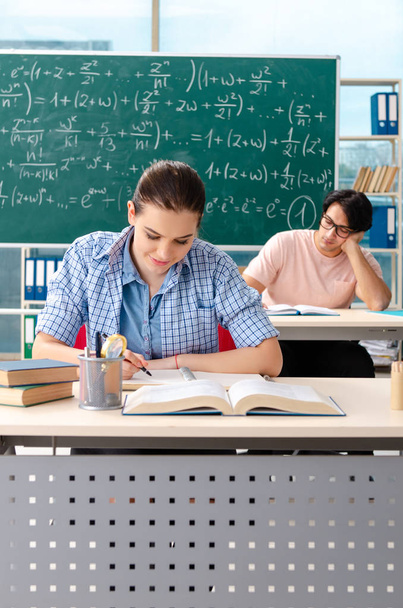Молодые студенты сдавали экзамен по математике в классе
  - Фото, изображение