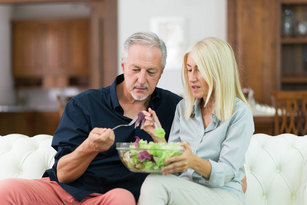 Disgusted couple eating salad - Foto, Imagen
