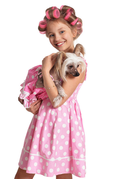 portrait of emotional little pretty girl with hair curlers posing with cute dog  isolated on white background - Fotografie, Obrázek
