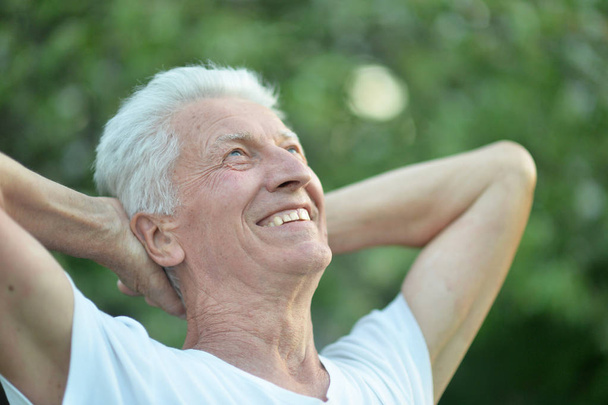 Porträt eines lächelnden Seniors im Park - Foto, Bild