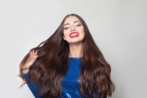 Счастливая брюнетка женщина с длинными волосами на белом фоне
.  - Фото, изображение