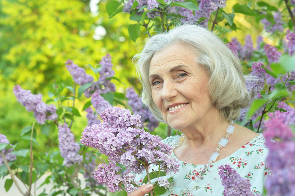 happy  senior beautiful woman with lilacs in spring  park - Fotoğraf, Görsel