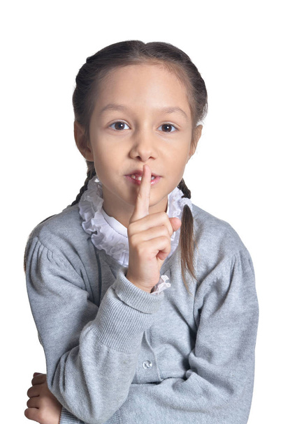 portrait of cute little girl holding finger on lips isolated on white background - Foto, afbeelding