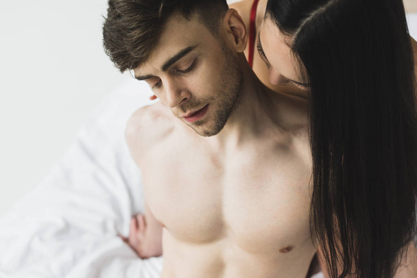 asian woman kissing neck of handsome shirtless boyfriend - Foto, immagini