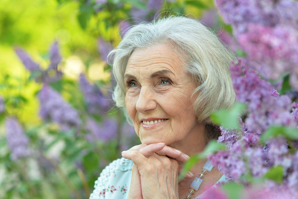 happy  senior beautiful woman on  lilacs background  in spring  park - Φωτογραφία, εικόνα