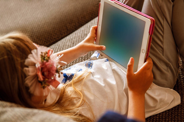 Девушка с помощью цифрового планшета на диване дома
. - Фото, изображение