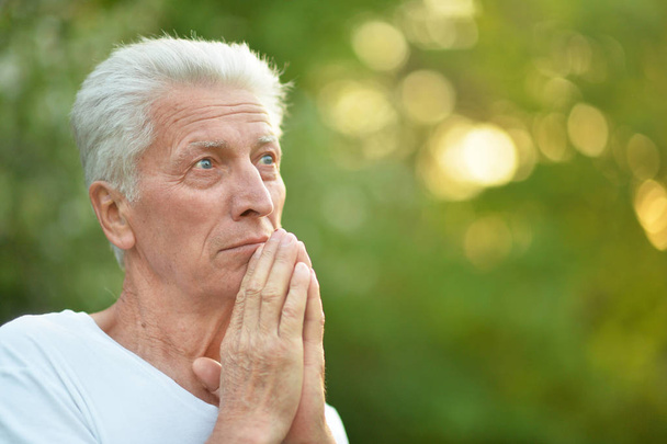 portrait of senior man  in  park praying  - Zdjęcie, obraz