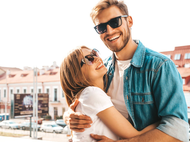 Portrait of smiling beautiful girl and her handsome boyfriend. Woman in casual summer jeans clothes. Happy cheerful family. Female having fun on the street background in sunglasses - Photo, image