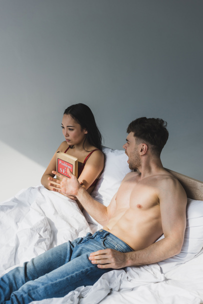口論のボーイフレンドの近くに横たわっている間、セックスブックで問題を抱えているアジアの女性を動揺させる - 写真・画像