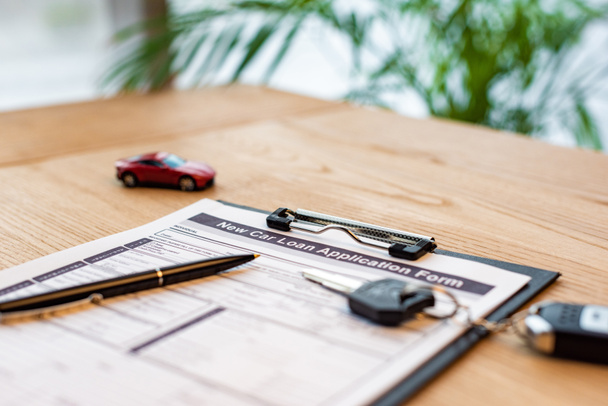selective focus of clipboard with document near pen, toy car and car key  - Foto, imagen
