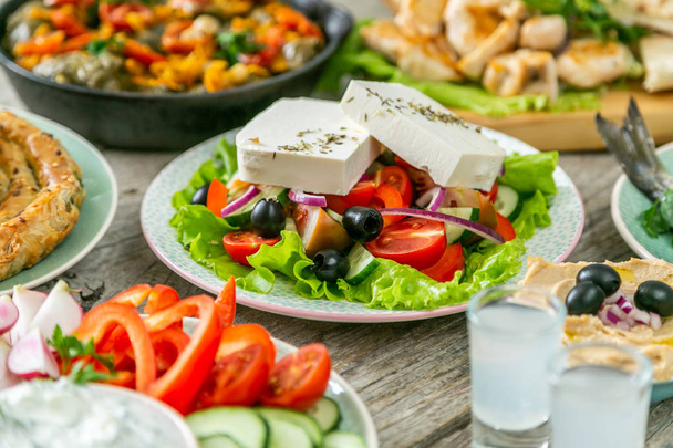 Selection of traditional greek food - salad, meze, pie, fish, tzatziki, dolma - Фото, изображение