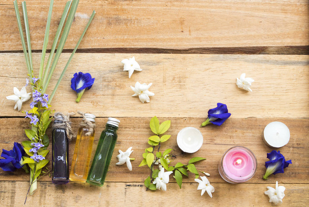 přírodní bylinné oleje extrakt vegetace citronové trávy, květiny Jasmína a modrá květinka motýlek voní vůně aroma aranžmá plochý ležel styl na pozadí dřevěné - Fotografie, Obrázek