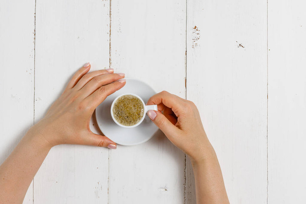 High angle of female hands hold a cup of strong coffee - Fotó, kép