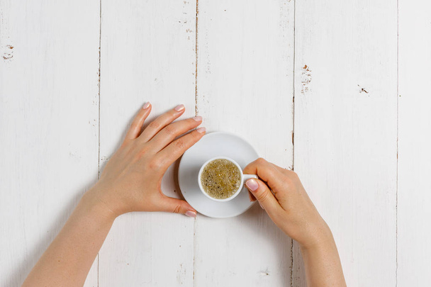 High angle of female hands hold a cup of strong coffee - Φωτογραφία, εικόνα