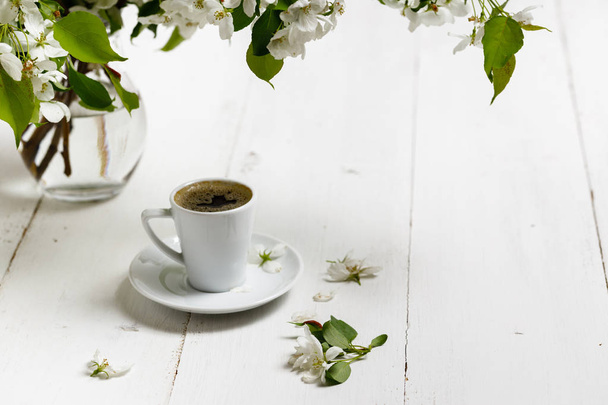 Spring still life. Cup of coffee with apple tree flowers and pet - Φωτογραφία, εικόνα