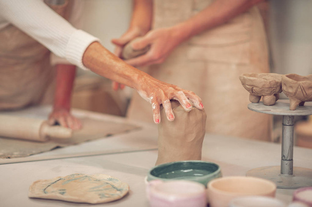 Close up of female hand touching clay piece - Valokuva, kuva